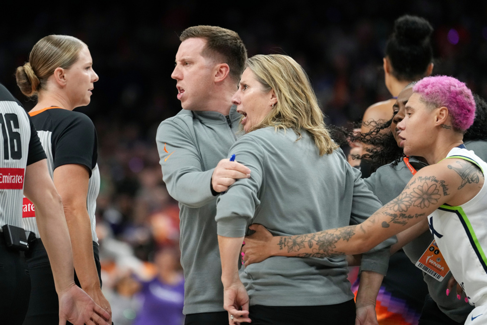 Minnesota Lynx head coach Cheryl Reeve, second from right, yells at officials as she is restrained by Lynx associate head coach Eric Thibault, center, and Lynx guard Natisha Hiedeman,