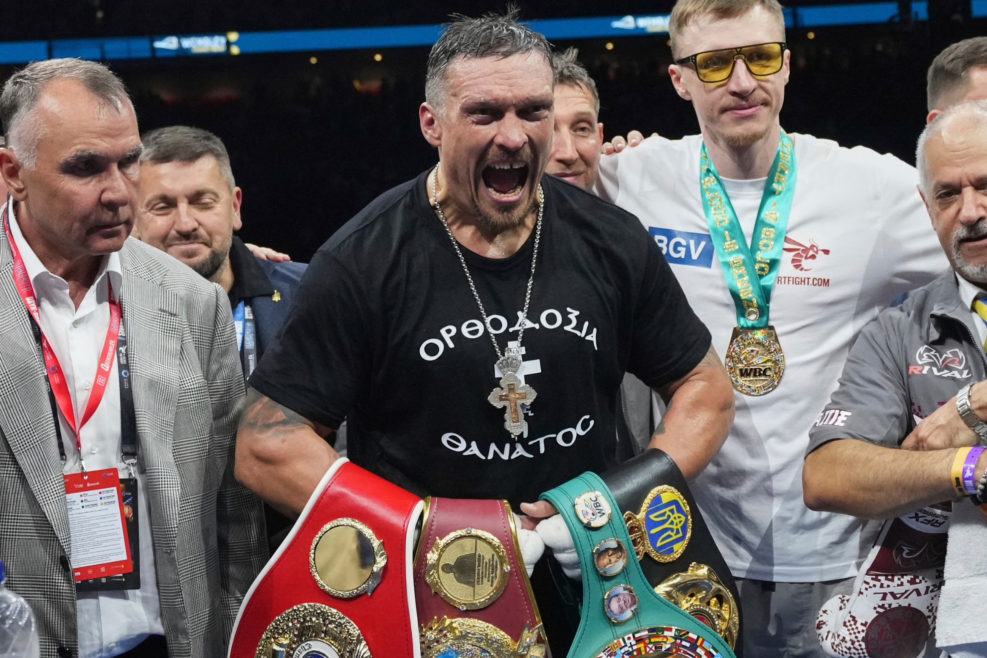Oleksandr Usyk celebrates with his undisputed heavyweight titles after defeating Daniel Dubois.