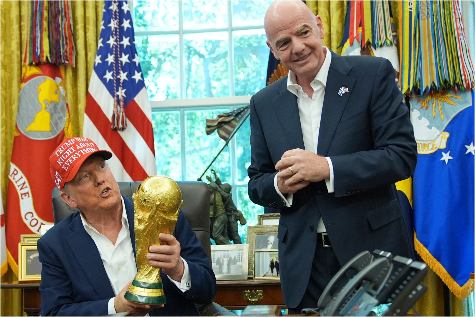 President Donald Trump holds the FIFA World Cup Winners Trophy as FIFA President Gianni Infantino.