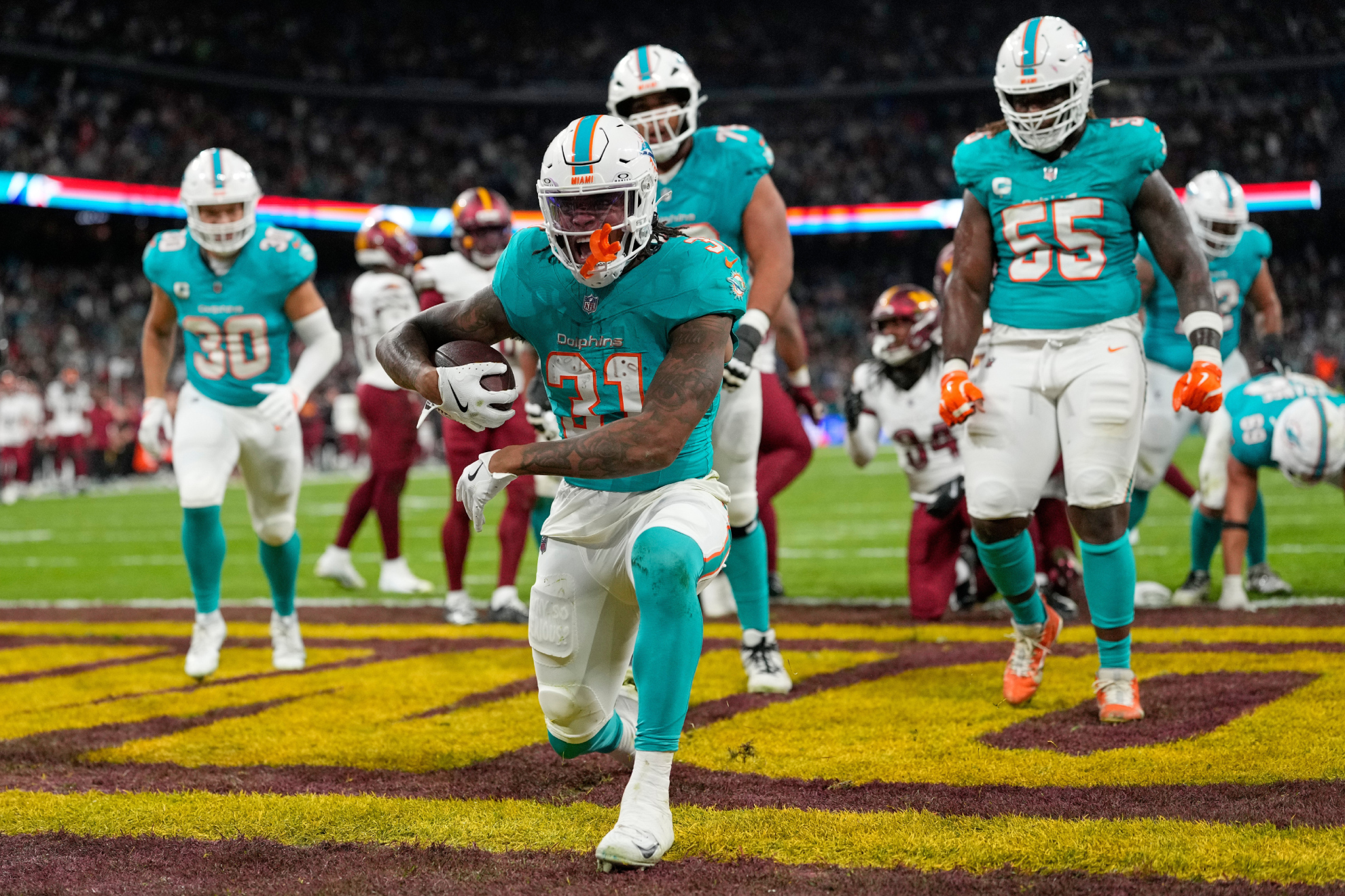 Miami Dolphins running back Ollie Gordon II (31), center, reacts after scoring a touchdown during the second half of an NFL football game between the Washington Commanders and the Miami Dolphins in Madrid, Spain, Sunday, Nov. 16, 2025.