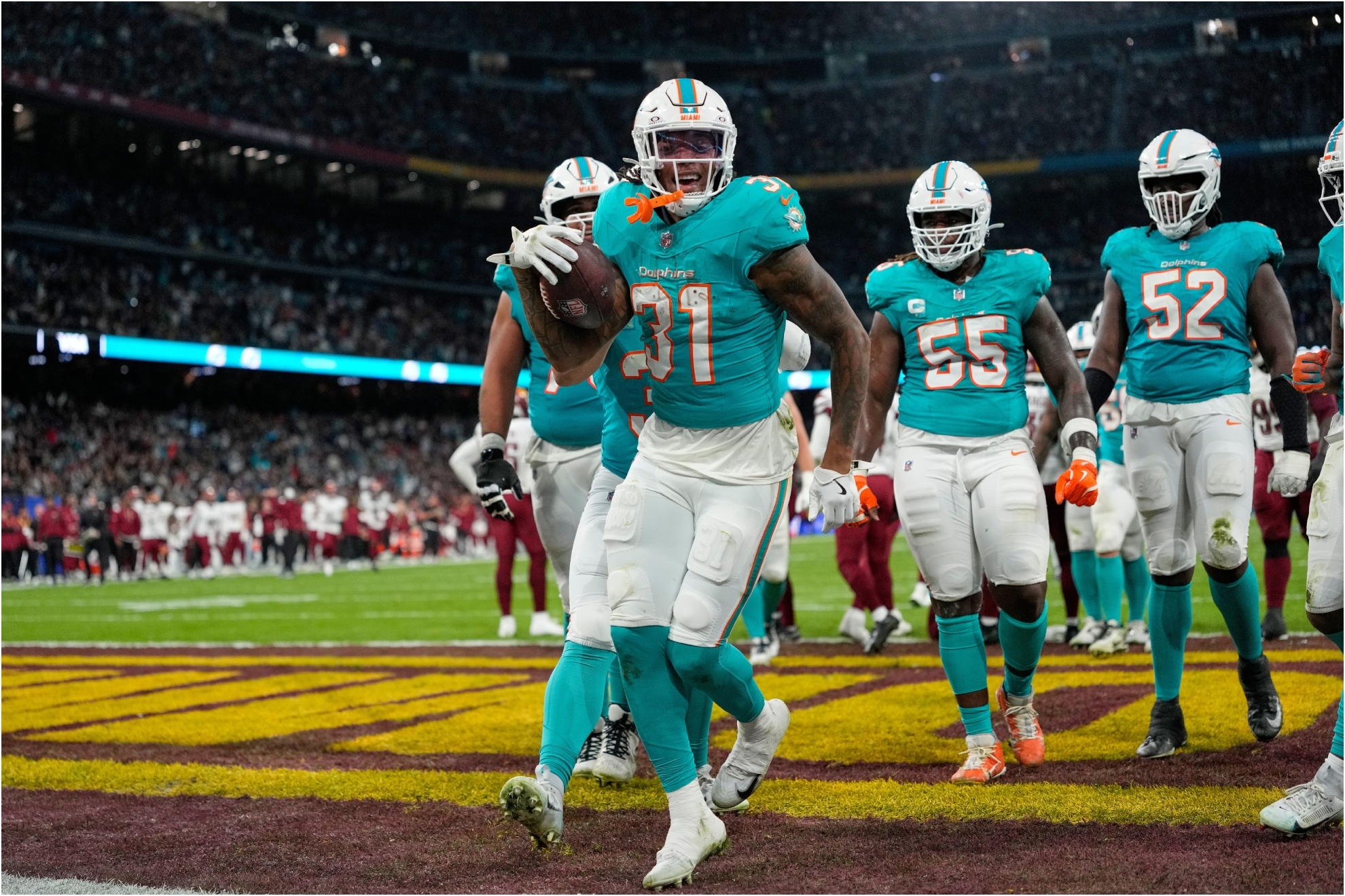 Miami Dolphins running back Ollie Gordon II (31), center, reacts after scoring a touchdown.