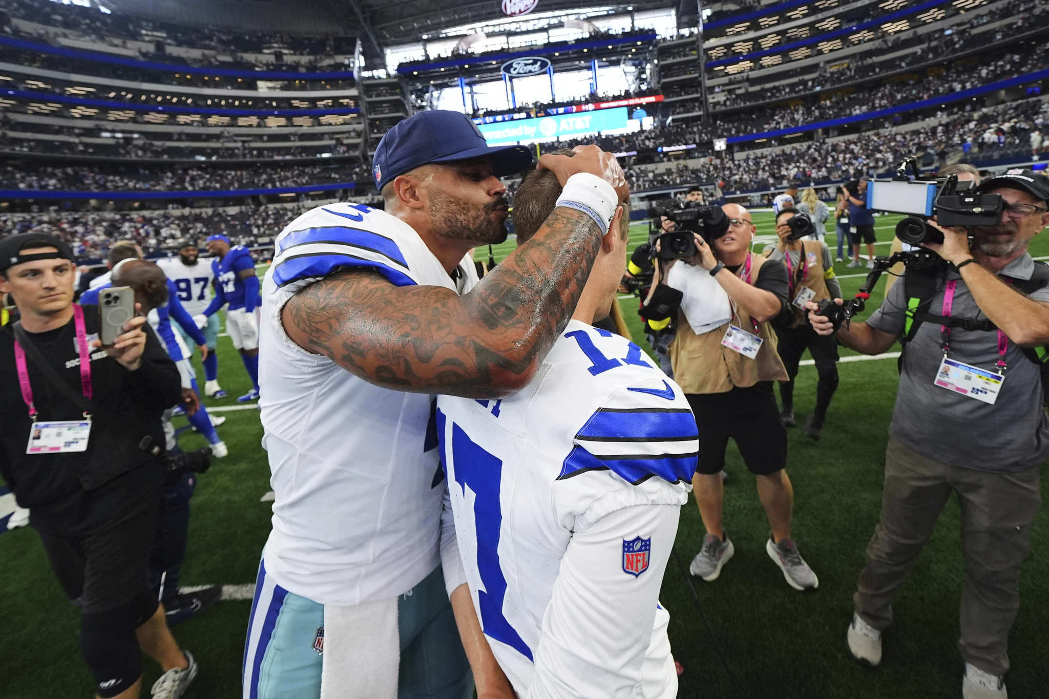 Dallas Cowboys quarterback Dak Prescott (4) gives place kicker Brandon Aubrey, right, a kiss on the head after the teams overtime win in an NFL football game against the New York Giants