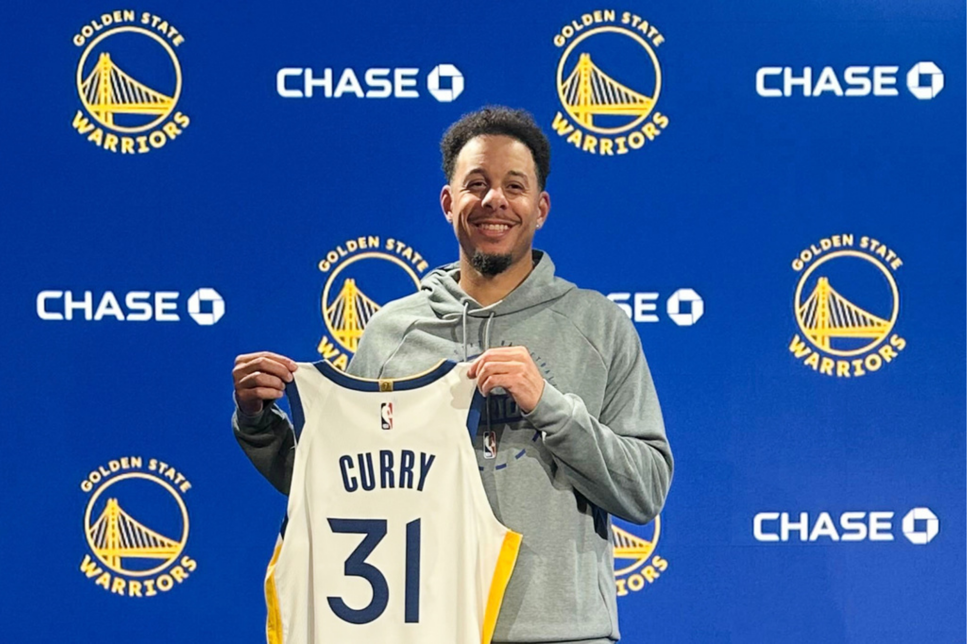 Golden State Warriors Seth Curry poses with his jersey during an introductory NBA basketball news conference