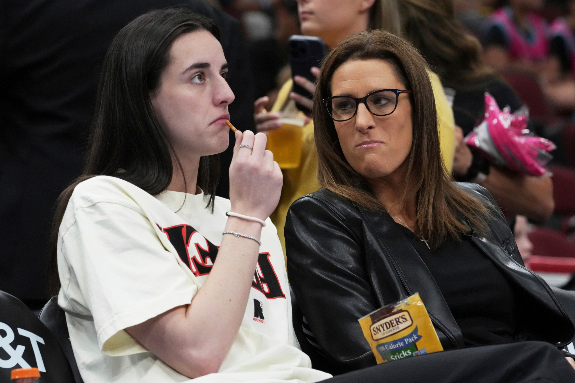 Caitlin Clark (left) sits courtside with Indiana Fever head coach Stephanie White (right) before a game against the Chicago Sky.