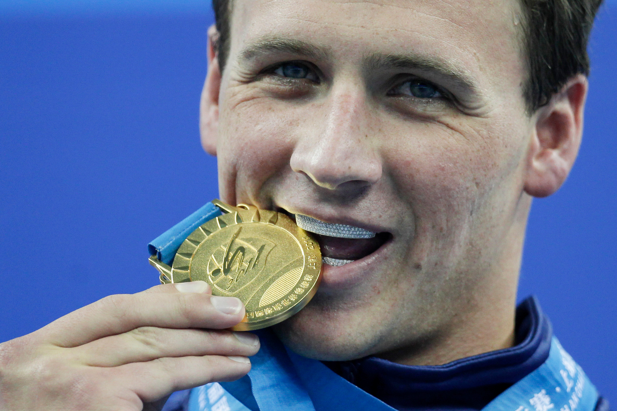 Ryan Lochte, of the United States, bites his gold medal for the mens 200 meters freestyle at the FINA Swimming World Championships in Shanghai, China, on July 26, 2011. Ryan Lochte told The Associated Press by phone Sunday, July 3, 2022, that he is auctioning off all of his Olympic silver and bronze medals, with the proceeds going to a charity benefitting children. The 37-year-old swimmer earned 12 medals over four Olympics, including six gold that he plans to keep for now.