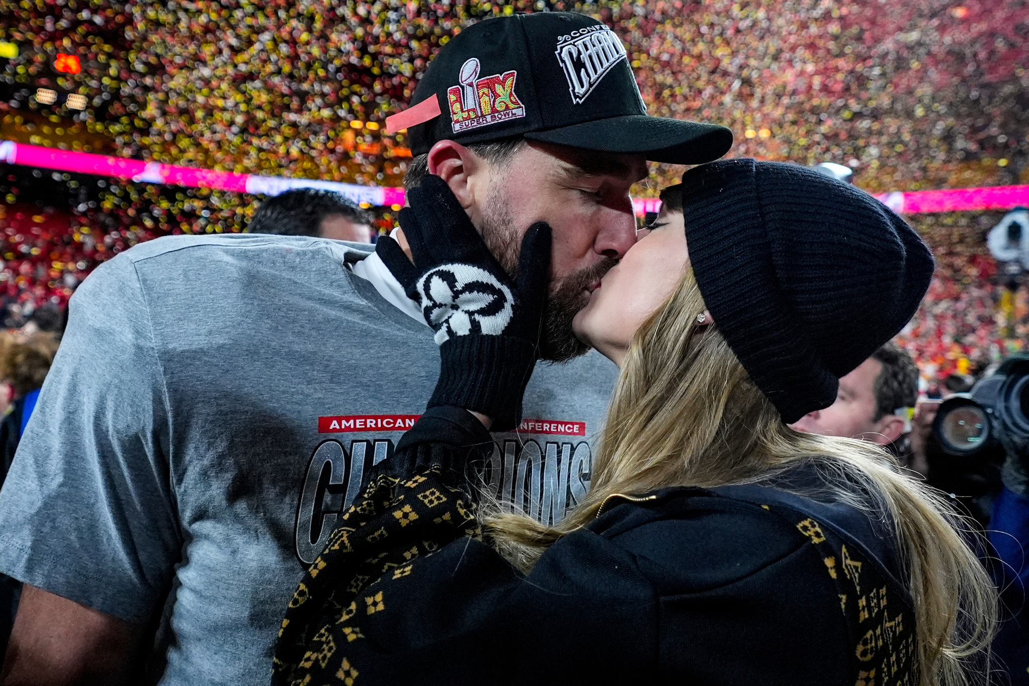 Travis Kelce and Taylor Swift share a kiss.