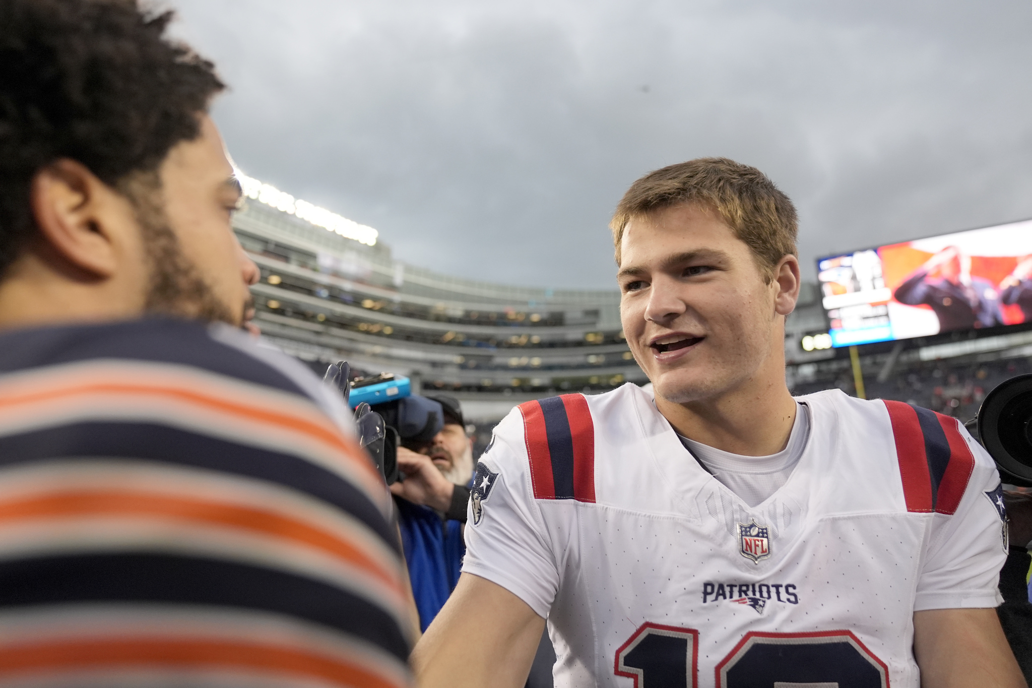 New England Patriots quarterback Drake Maye, right, and Chicago Bears quarterback Caleb Williams meet after the Patriots win over the Bears