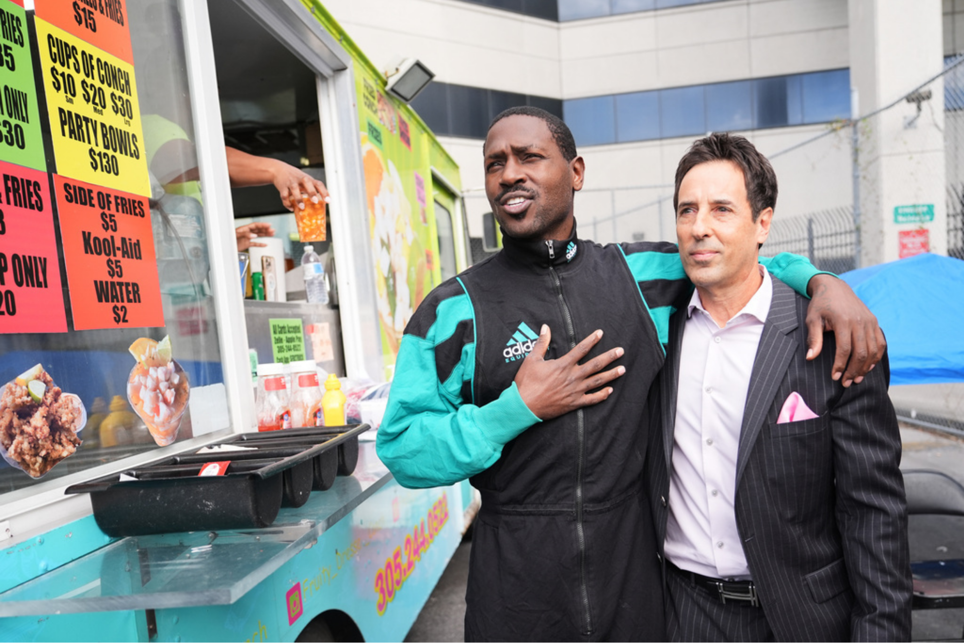 Former NFL star wide receiver Antonio Brown, left, stands at a food truck with his attorney Mark Russell Eiglarsh, right,
