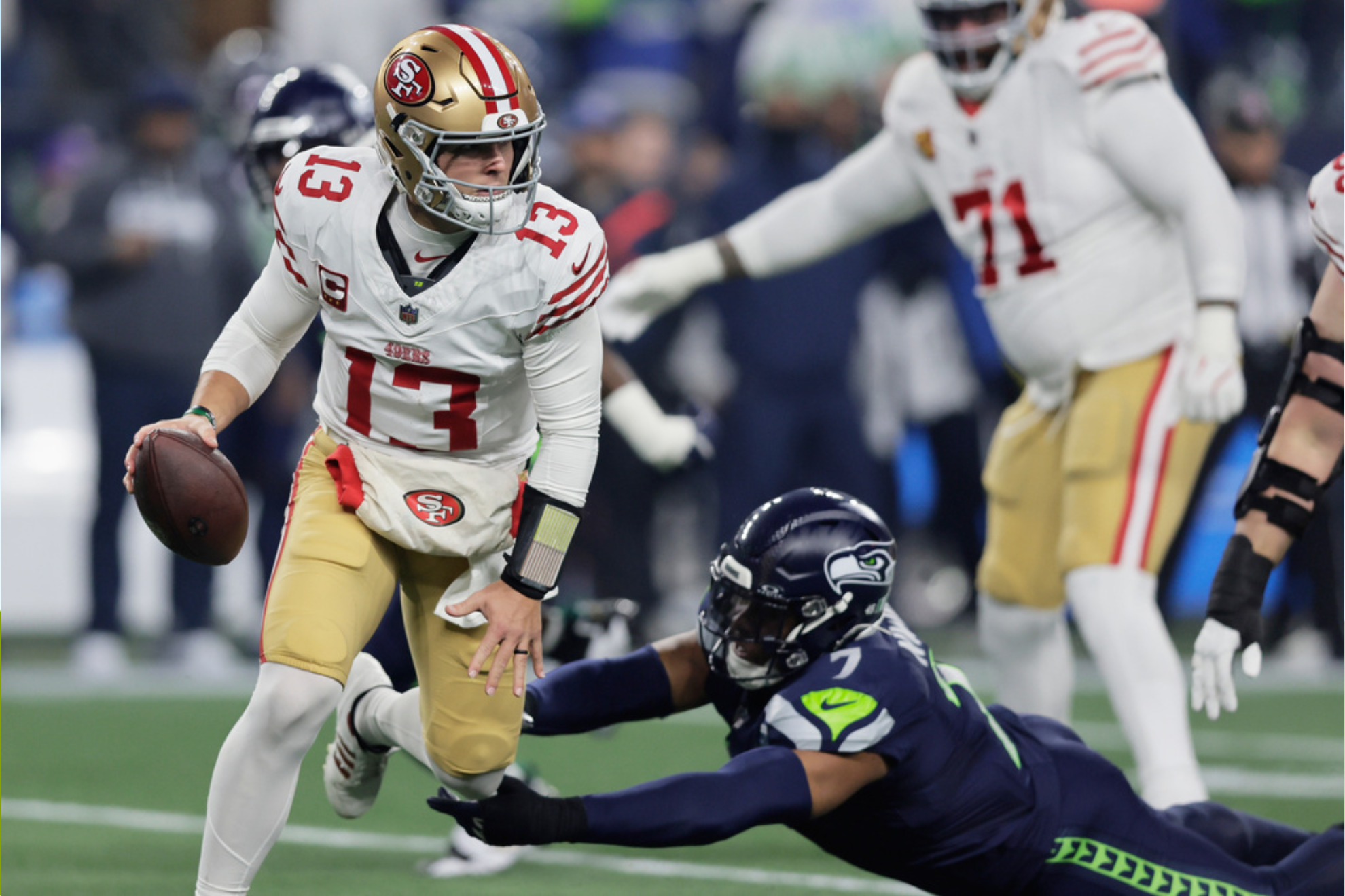 San Francisco 49ers quarterback Brock Purdy (13) scrabbles to avoid Seattle Seahawks linebacker Uchenna Nwosu (7)