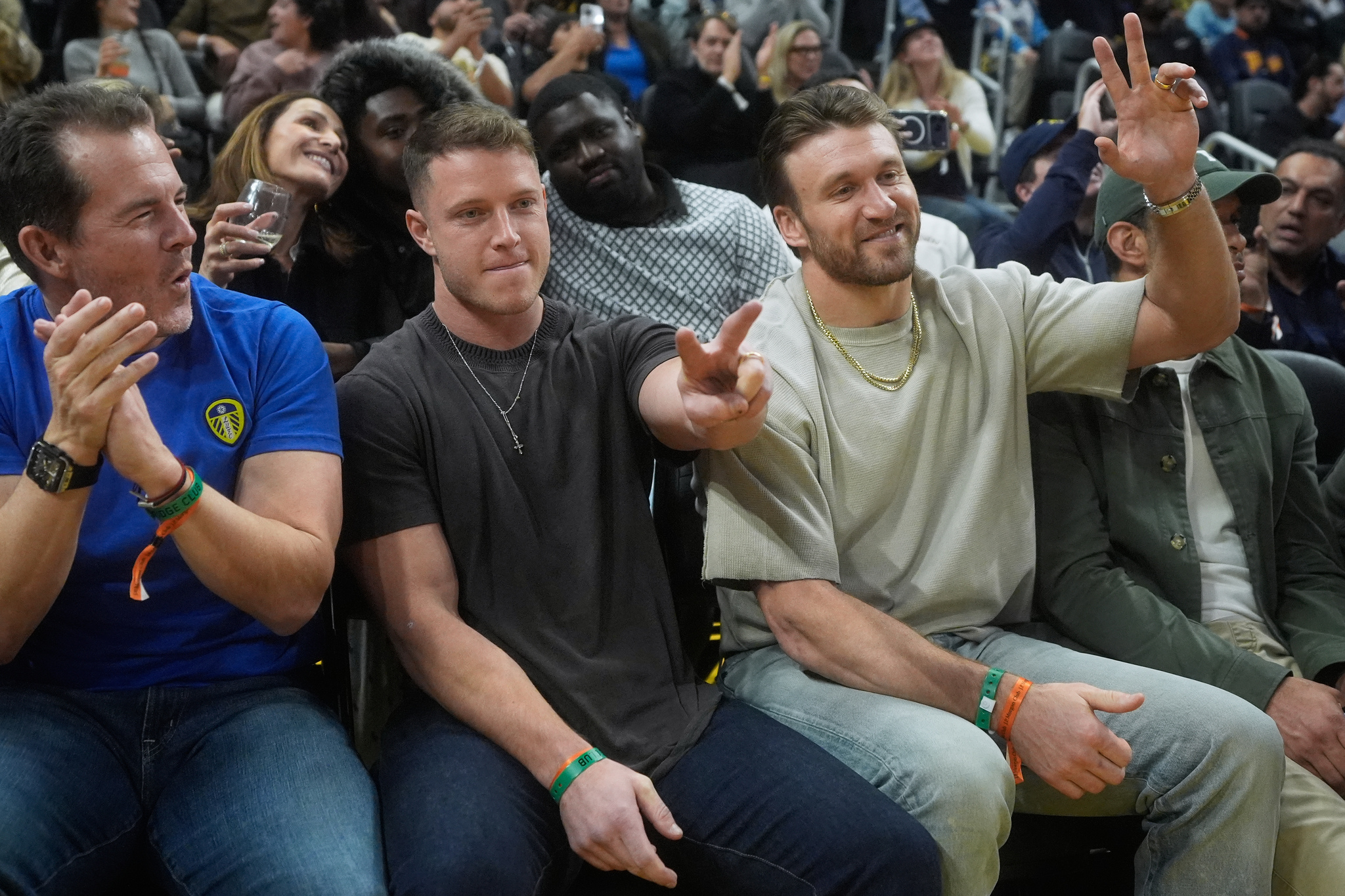 San Francisco 49ers football players lt;HIT gt;Christian lt;/HIT gt; lt;HIT gt;McCaffrey lt;/HIT gt;, middle left, and Kyle Juszczyk, middle right, gesture during the first half of an NBA basketball game between the Golden State Warriors and the Miami Heat in San Francisco, Monday, Jan. 19, 2026. (AP Photo/Jeff Chiu)