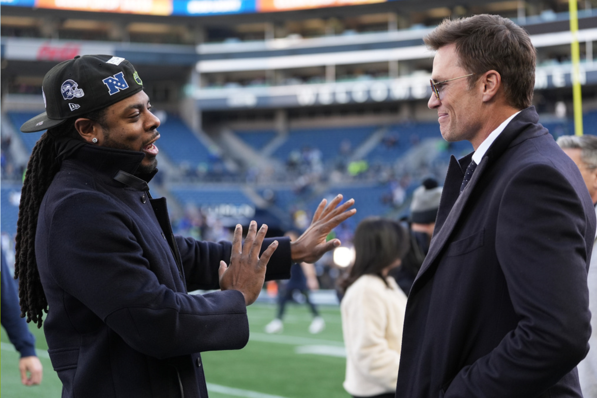 Former NFL players Richard Sherman, left, and Tom Brady talk before the NFC Championship
