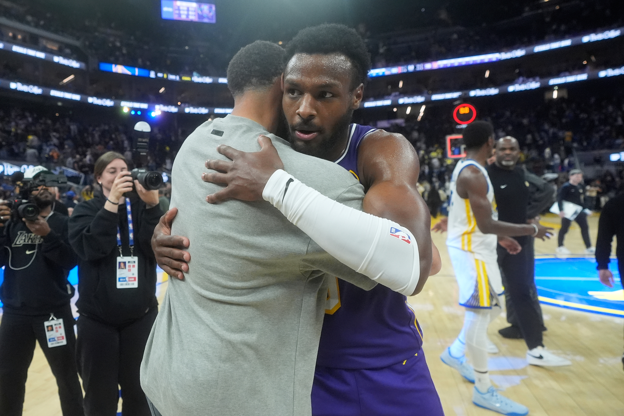 Golden State Warriors guard Stephen Curry, left, hugs Los Angeles Lakers guard Bronny James after an NBA basketball game in San Francisco