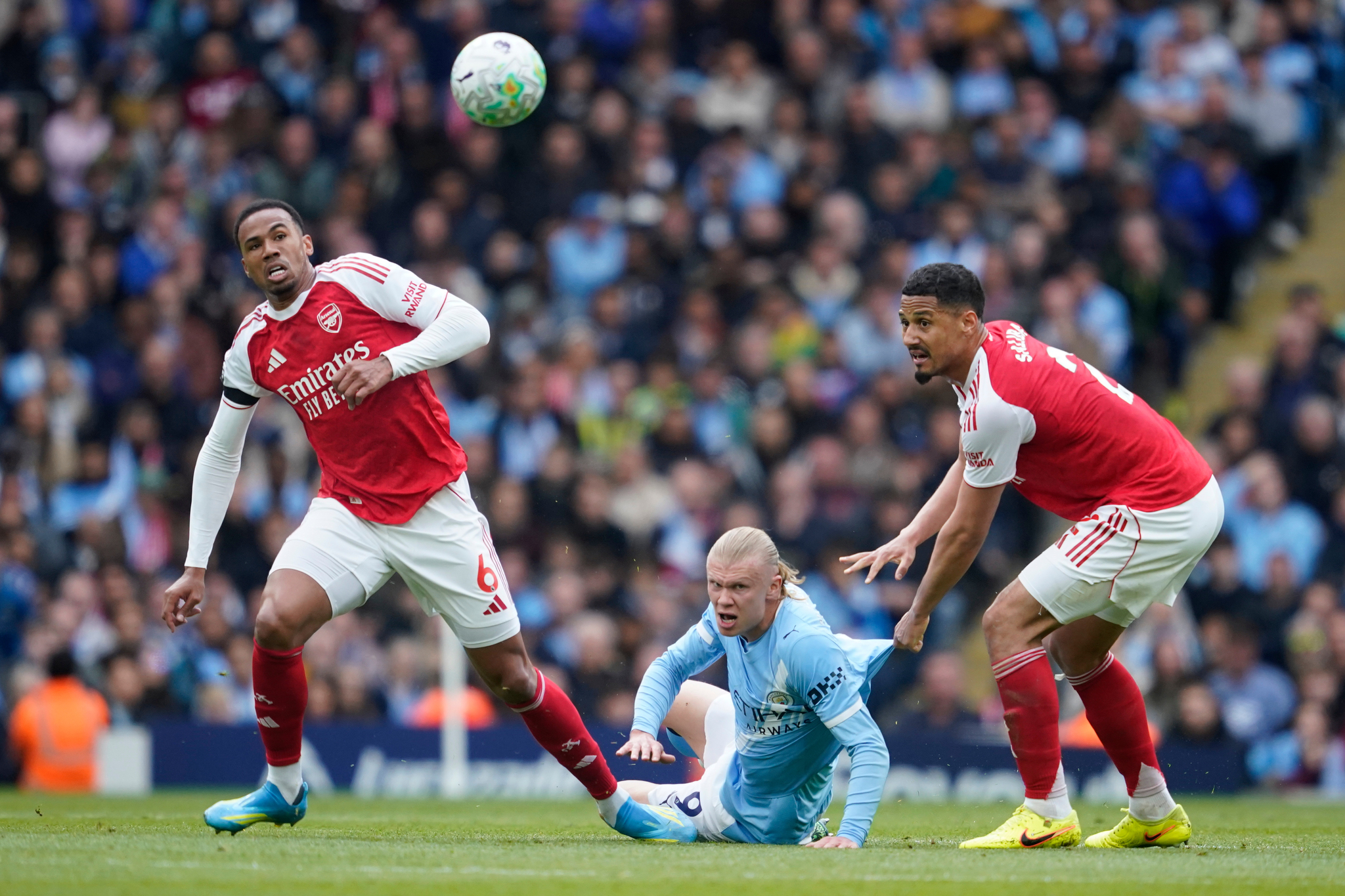 Manchester Citys Erling lt;HIT gt;Haaland lt;/HIT gt;, center, challenges for the ball with Arsenals lt;HIT gt;Gabriel lt;/HIT gt;, left and his teammate William Saliba during the English Premier League soccer match between Manchester City and and Arsenal, in Manchester, England, Sunday, April 19, 2026. (AP Photo/Dave Thompson)