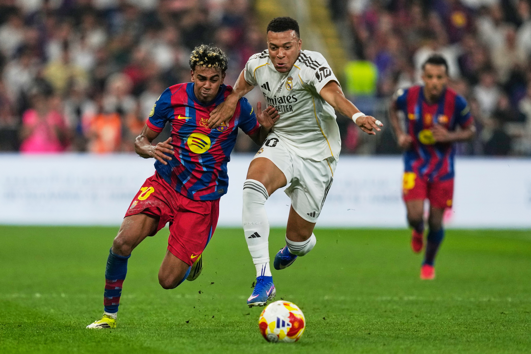 Barcelonas Lamine Yamal, left, duels for the ball with Real Madrids Kylian Mbappe during the Spanish Super Cup final