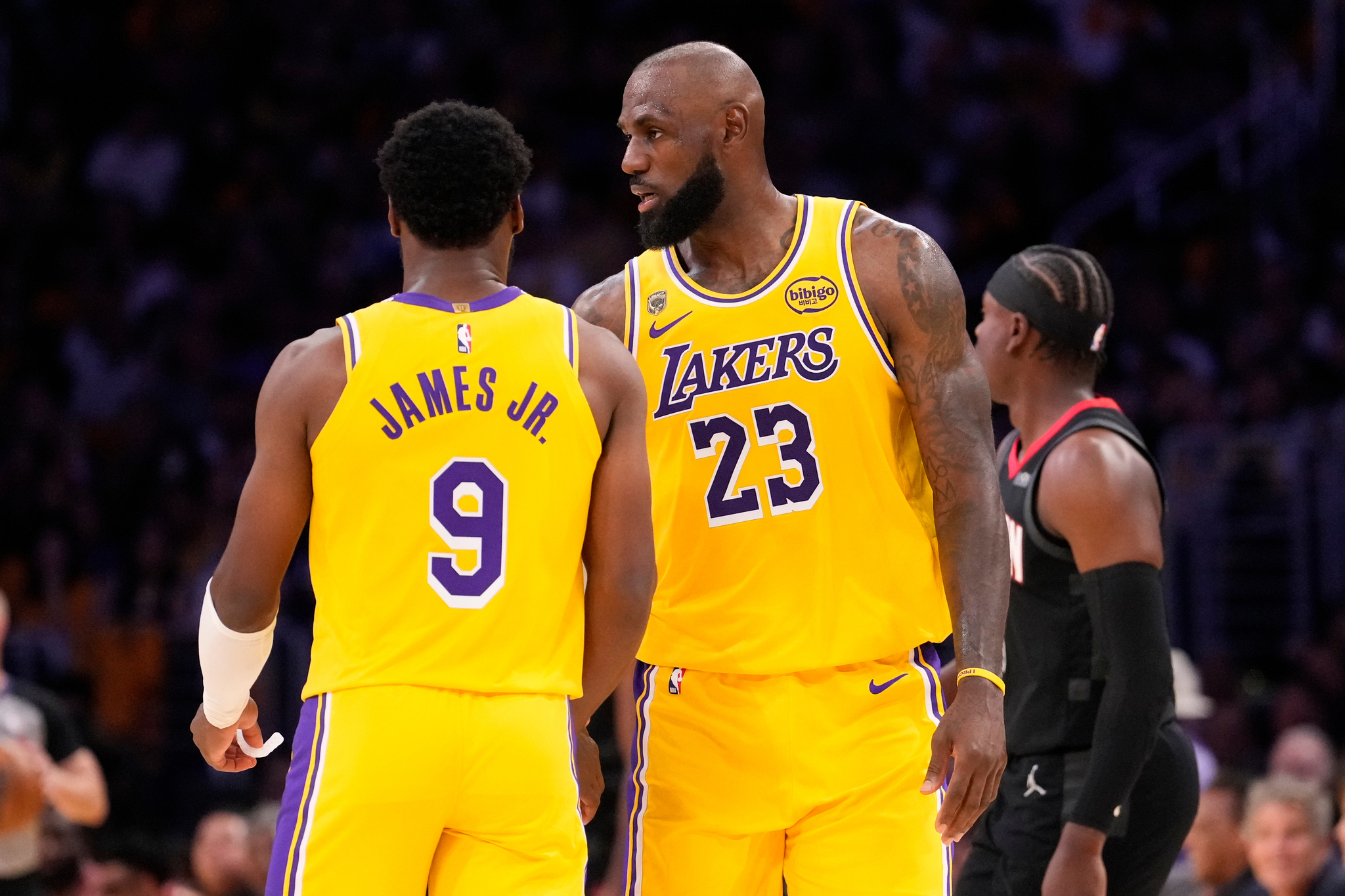 Los Angeles Lakers forward LeBron James, right, talks to his son guard Bronny James