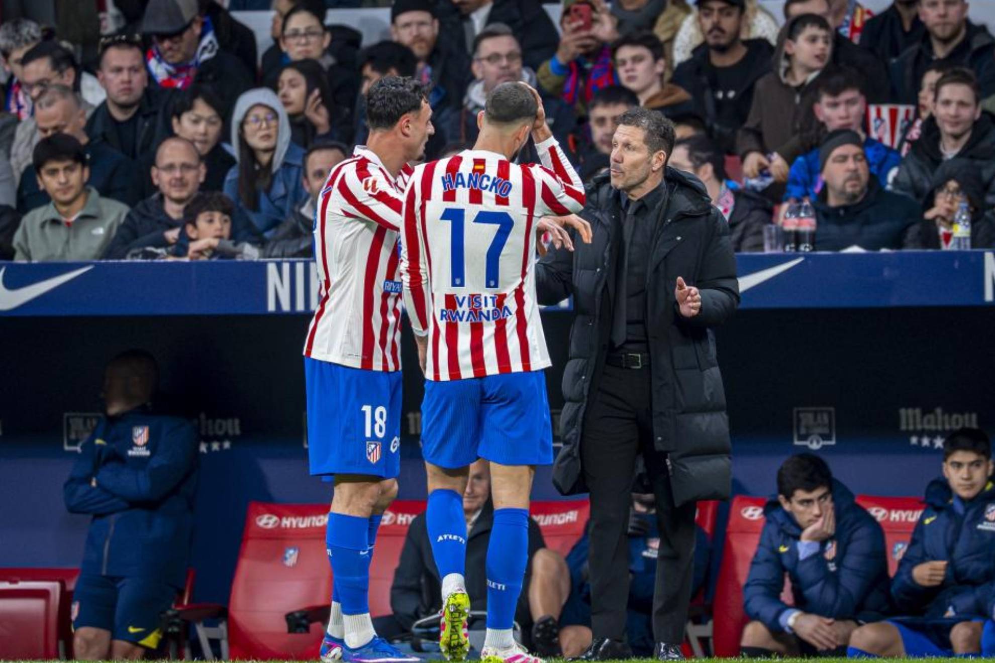 Simeone habla con Pubill y Hancko en un partido.
