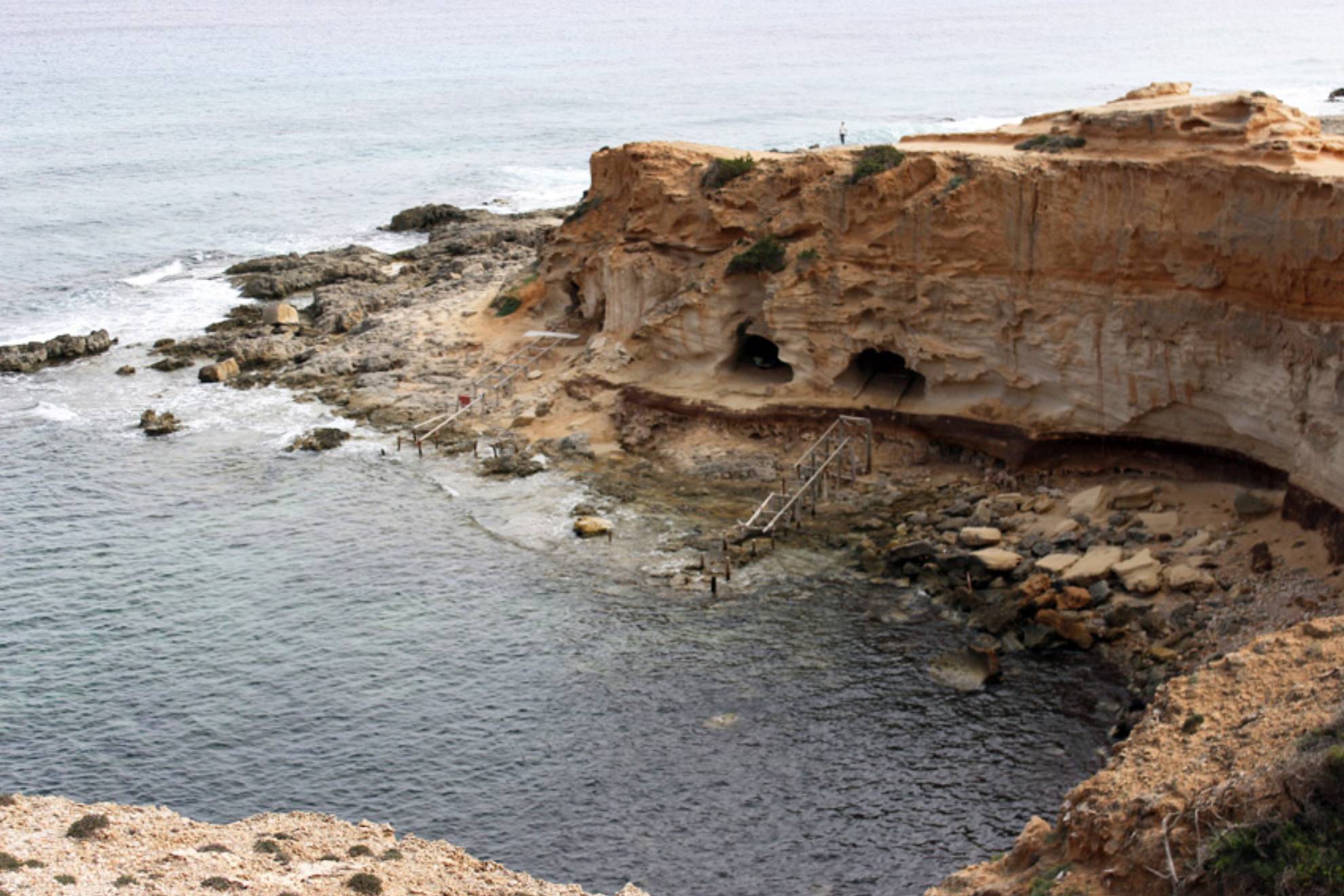 Ni Ses Illetes ni Migjorn: la cala de Formentera que parece una piscina natural tallada en la roca y que esconde cuevas entre acantilados imposibles