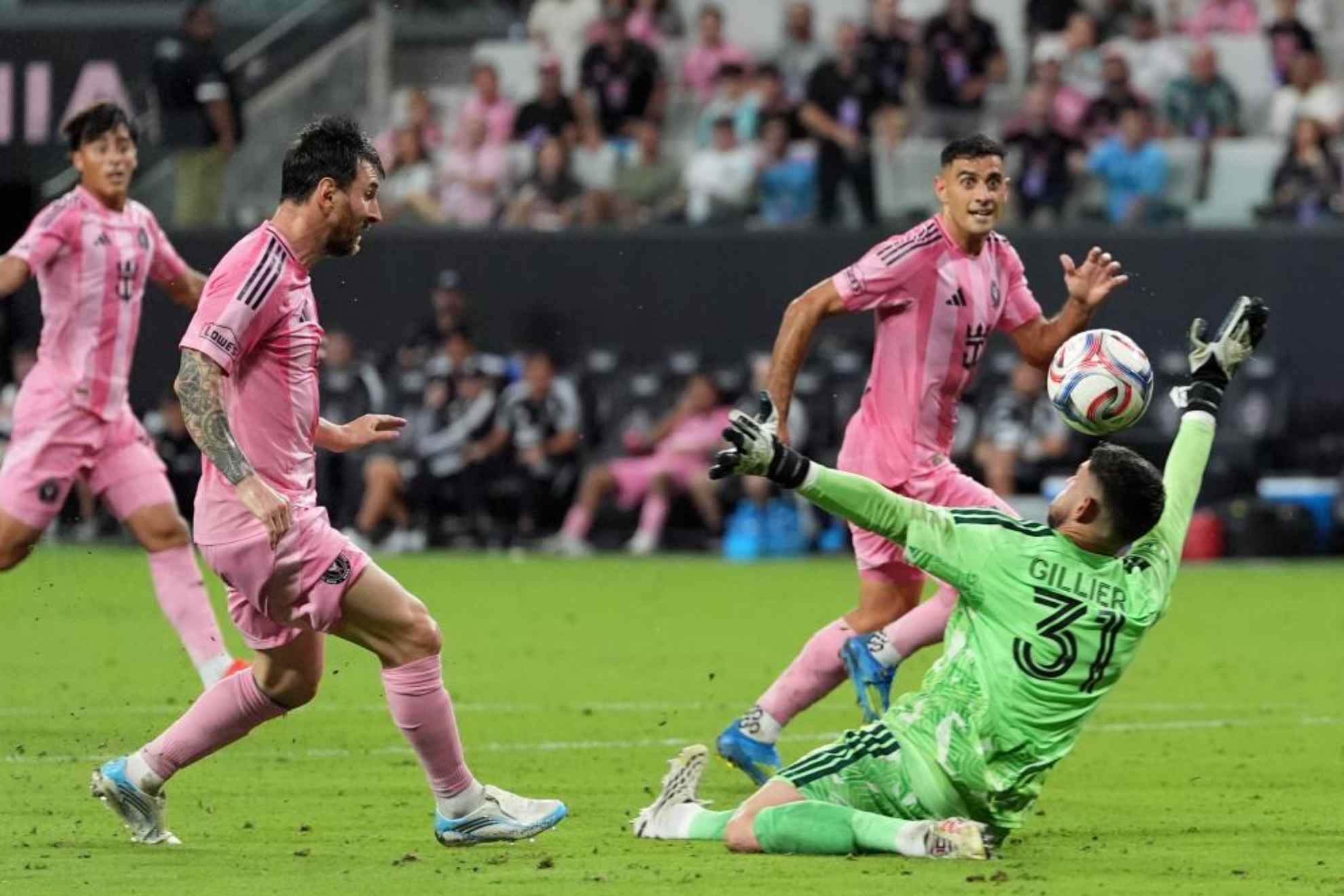 Leo Messi define por encima de  Thomas Gillier para hacer el tercero de sus cuatro goles a Montreal.