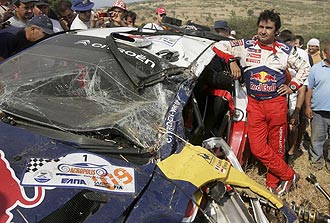 Daniel Elena, copiloto de Loeb, apoyado en su Citro�n C4, destrozado tras el accidente.