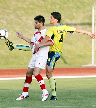 David Aganzo intenta controlar el bal�n ante la presi�n del central amarillo Lamas en el amistoso de Las Rozas