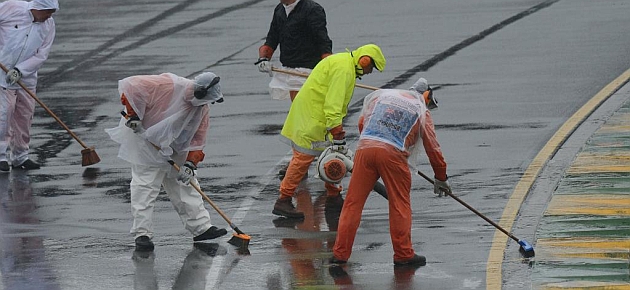 Operarios intentar secar la pista, sin �xito / REUTERS